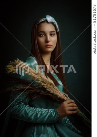 Portrait of a beautiful woman with medieval dress and teardrop on eye, isolated dark background 81781678