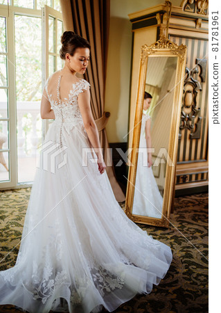 the bride at the mirror. selective focus. trying on a wedding dress the bride at the mirror. selective focus. trying on a wedding dress 81781961