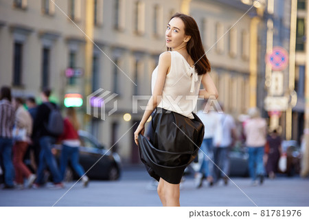 Female 18 years on crowded street in evening. 81781976