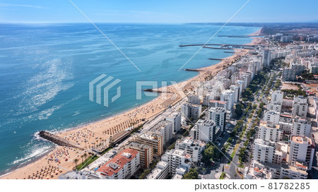 Beautiful aerial cityscapes of the tourist Portuguese city of Quarteira. On the seashore during the beach season with tourists who are sunbathing. Beautiful aerial cityscapes of the tourist Portuguese city of Quarteira. On the seashore during the beach season with tourists who are sunbathing. 81782285