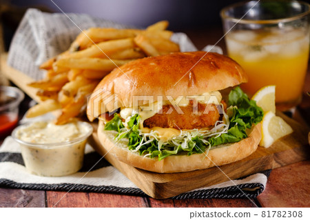 A hearty fish burger set with tartar sauce, fries and juice A hearty fish burger set with tartar sauce, fries and juice 81782308