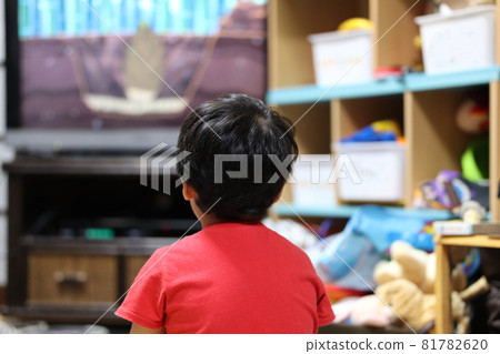 A hunchbacked child is watching cartoons on TV 81782620
