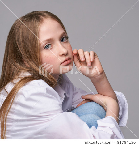 Young beautiful girl. Serious model with hand near face Young beautiful girl. Serious model with hand near face 81784150