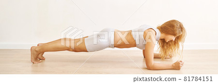 Young pretty woman standing in plank. Yoga exercise at gym. Home sport workout Young pretty woman standing in plank. Yoga exercise at gym. Home sport workout 81784151