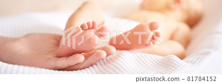 Newborn legs. Sister holding little feet. Two people Newborn legs. Sister holding little feet. Two people 81784152