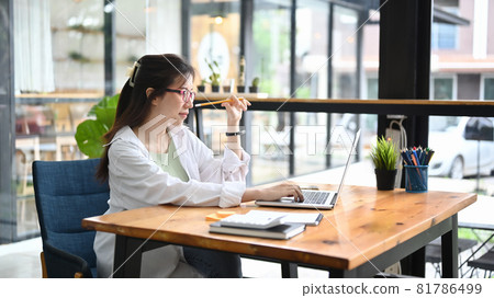 Thoughtful businesswoman working with laptop computer in modern workplace. 81786499