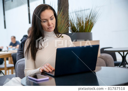 young woman with protective face mask works on laptop in cafe... young woman with protective face mask works on laptop in cafe... 81787518