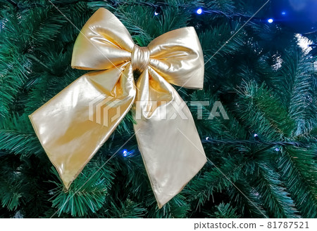 golden fabric bow decoration on a Christmas new year tree, close-up, soft focus golden fabric bow decoration on a Christmas new year tree, close-up, soft focus 81787521