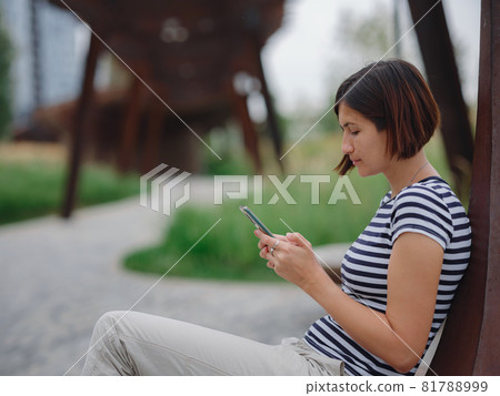 woman in modern park spending her break time woman in modern park spending her break time 81788999