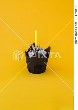 Delicious chocolate cupcake with cream and candle on dark background. Chocolate muffin. Birthday cake party. Delicious chocolate cupcake with cream and candle on dark background. Chocolate muffin. Birthday cake party. 81790332