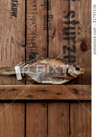 Sun-dried roach with paper label on tail on rough wooden boards Sun-dried roach with paper label on tail on rough wooden boards 81791516