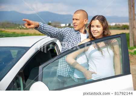 Positive young couple talking near car on spring day Positive young couple talking near car on spring day 81792144