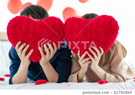 Unrecognizable couple hiding faces behind hearts 81792864