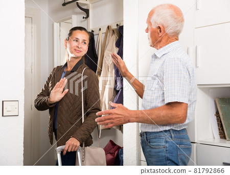 Father says goodbye to her adult daughter in the hallway of the apartment 81792866
