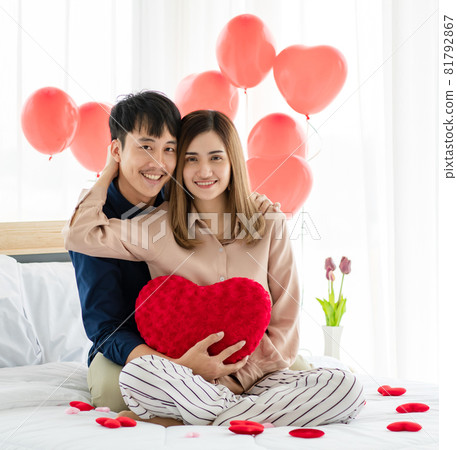 Asian man and woman hugging on bed 81792867