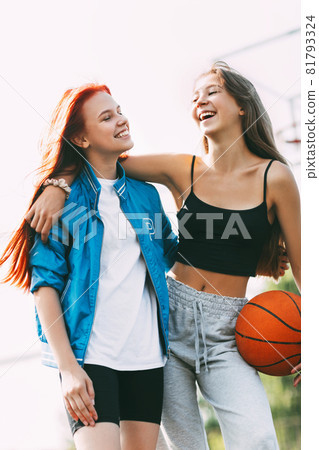 Two funny girls with a basketball hug each other after a game or workout. The concept of sports and friendship 81793324