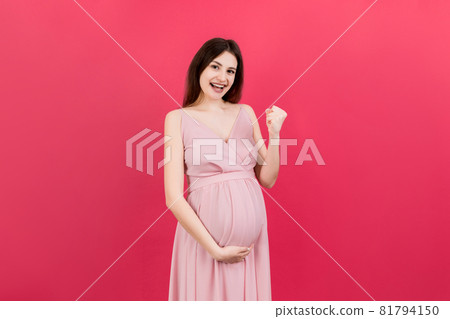 Young beautiful pregnant woman on isolated colored background celebrating surprised and amazed for success with arms raised and open eyes. Winner concept 81794150
