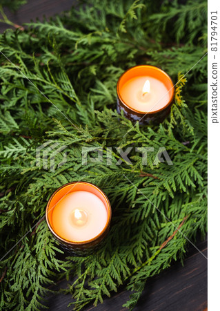 Christmas composition with fir branches and candles. Festive arrangement for Christmas or New Year. 81794701