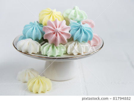 Small colorful meringues on the ceramic  stand 81794882