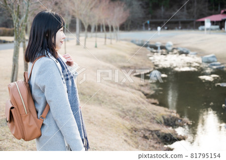 A woman nestled in the murmuring of a winter park A woman nestled in the murmuring of a winter park 81795154