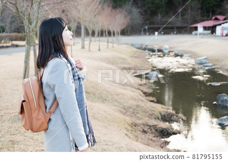 A woman nestled in the murmuring of a winter park A woman nestled in the murmuring of a winter park 81795155