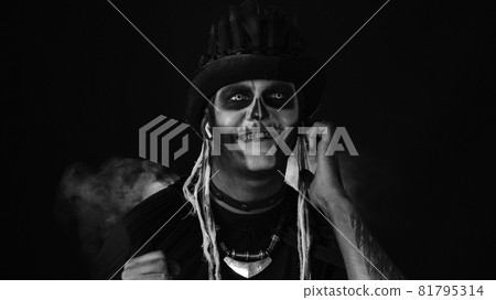Scary guy in costume of Halloween skeleton wearing earphones, listening music, dancing, celebrating 81795314