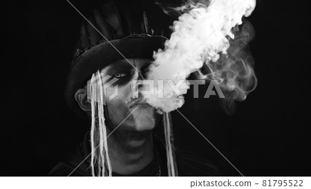 Frightening man in creepy skeleton Halloween cosplay exhaling cigarette smoke from his mouth Frightening man in creepy skeleton Halloween cosplay exhaling cigarette smoke from his mouth 81795522