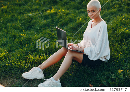 Millenial young woman blonde short hair outdoor smiling portrait with laptop. Millenial young woman blonde short hair outdoor smiling portrait with laptop. 81795747