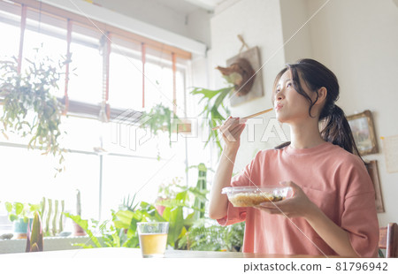 Young woman eating in the room 81796942