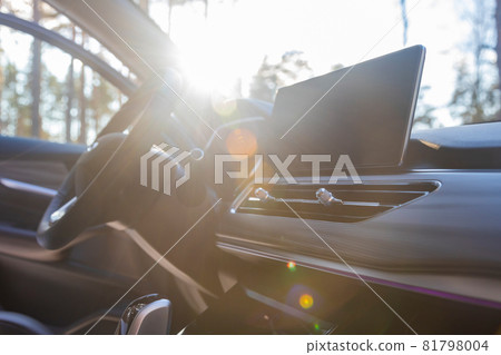 empty interior of a premium car in the sun. mnultimedia monitor, interior ventilation deflectors, steering wheel empty interior of a premium car in the sun. mnultimedia monitor, interior ventilation deflectors, steering wheel 81798004