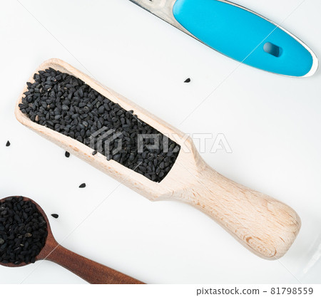 top view of Nigella sativa seeds (black caraway) in scoop and spoons on white plate top view of Nigella sativa seeds (black caraway) in scoop and spoons on white plate 81798559