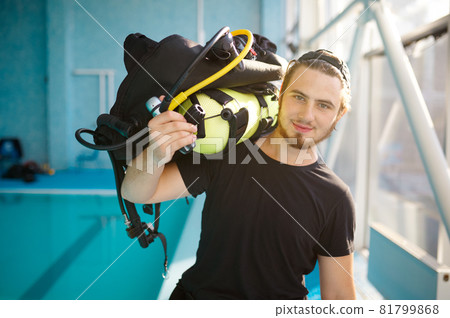 Male diver holds scuba gear, diving school 81799868