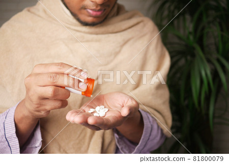 man's hand with medicine spilled out of the pill container man's hand with medicine spilled out of the pill container 81800079