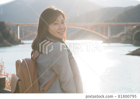 A woman standing in the background of Lake Miyagase, where the setting sun reflects A woman standing in the background of Lake Miyagase, where the setting sun reflects 81800795