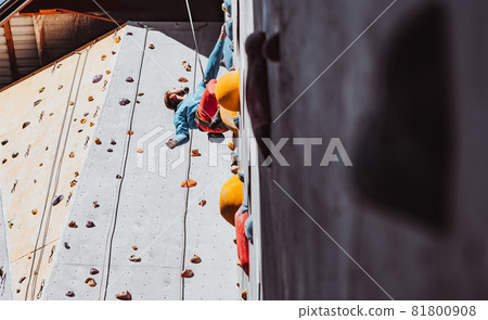 Young man professional rock climber practicing at training center in sunny day, outdoors. Concept of healthy lifestyle, tourism, nature, motion. 81800908