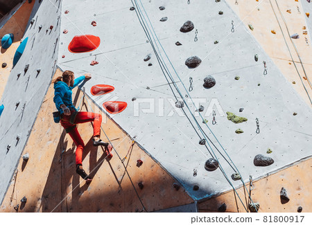 Hard level. Young man professional rock climber practicing at training center in sunny day, outdoors. Concept of healthy lifestyle, tourism, nature, motion. 81800917