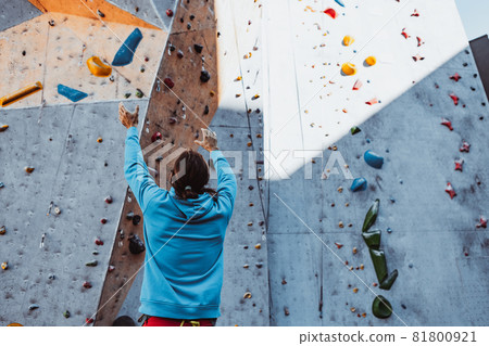 Safety climbing. Young man professional rock climber checking sports equipment before climbing at training center in sunny day, outdoors. Safety climbing. Young man professional rock climber checking sports equipment before climbing at training center in sunny day, outdoors. 81800921