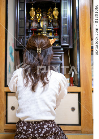 一位年輕女子手牽手在佛陀之間的祭壇上的背影 81801066