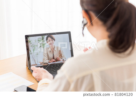 A woman having an online meeting during teleworking at home 81804120