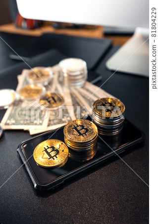 Stacked bitcoins grow on the desk. Stacked bitcoins grow on the desk. 81804229