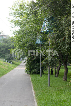 Large street lamp in the form of a table lamp in a city park 81806425