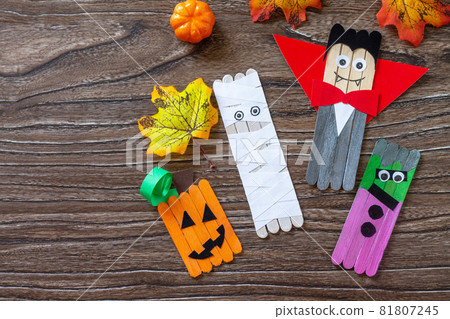 Halloween ghost and vampire toy gift stics puppets on wooden table. Handmade. Project of children's creativity, handicrafts, crafts for kids. Halloween ghost and vampire toy gift stics puppets on wooden table. Handmade. Project of children's creativity, handicrafts, crafts for kids. 81807245