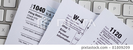 Tax form documents lying on computer keyboard closeup Tax form documents lying on computer keyboard closeup 81809209
