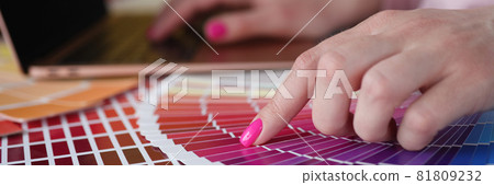 Woman with pink manicure showing color swatches in catalog closeup Woman with pink manicure showing color swatches in catalog closeup 81809232