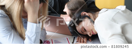 Tired business woman sleeping at table in office Tired business woman sleeping at table in office 81809245
