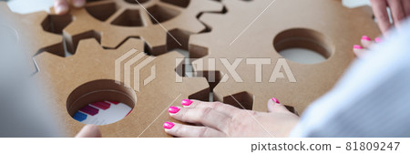 Group of business people stacking wooden gears closeup 81809247