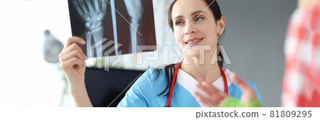 Doctor examines patient hand injury on an X-ray Doctor examines patient hand injury on an X-ray 81809295