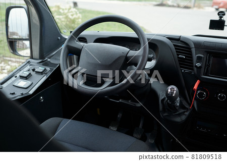 Close-up of drivers seat, bus dashboard and steering wheel, view through windshield Close-up of drivers seat, bus dashboard and steering wheel, view through windshield 81809518