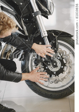 Handsome man choosing a motorcycle to buy 81810656