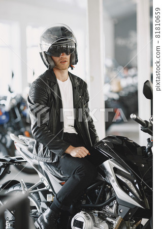 Handsome man choosing a motorcycle to buy Handsome man choosing a motorcycle to buy 81810659